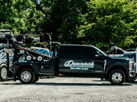 Dependable pickup wrecker parked beside the heavy rotator on a gravel lot