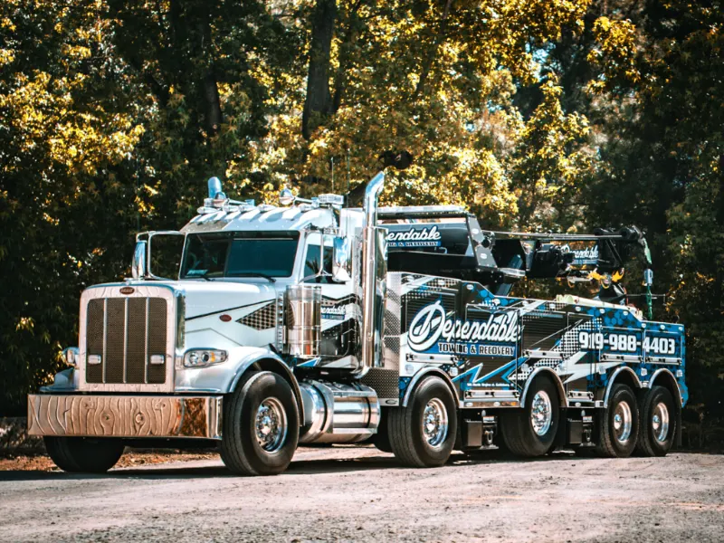Dependable Towing & Recovery 60-ton rotator parked on a gravel lot