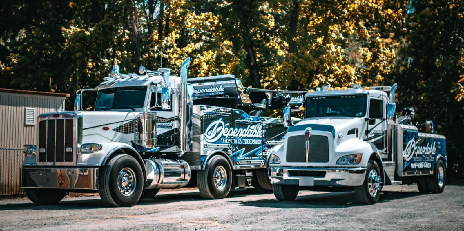 Dependable Towing & Recovery heavy rotator and wrecker parked side by side on a gravel lot